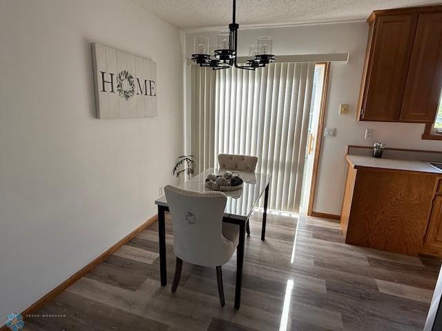 408 Np Ct, Breckenridge, MN 56520 - dining space featuring wood finished floors, a textured ceiling, a chandelier, and baseboards