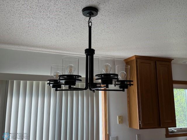 408 Np Ct, Breckenridge, MN 56520 - detailed view of a textured ceiling, brown cabinetry, and a chandelier
