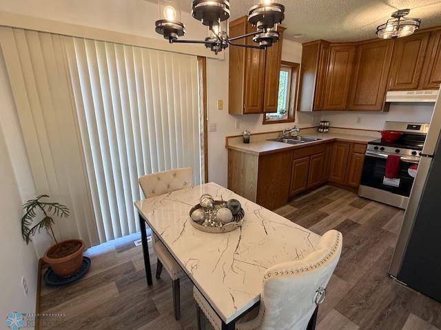 408 Np Ct, Breckenridge, MN 56520 - kitchen featuring a sink, stainless steel electric stove, a chandelier, dark wood-type flooring, and brown cabinets