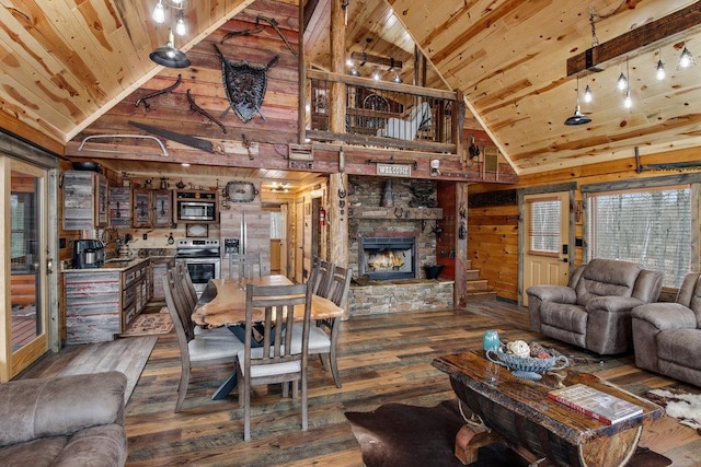 29917 Bay Dr, Danbury, WI 54830 - living area featuring wooden ceiling, wood-type flooring, high vaulted ceiling, a stone fireplace, and wooden walls