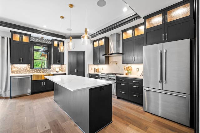 5191 159th Ave NW, Andover, MN 55304 - kitchen featuring high end appliances, wall chimney exhaust hood, light wood finished floors, dark cabinetry, and crown molding