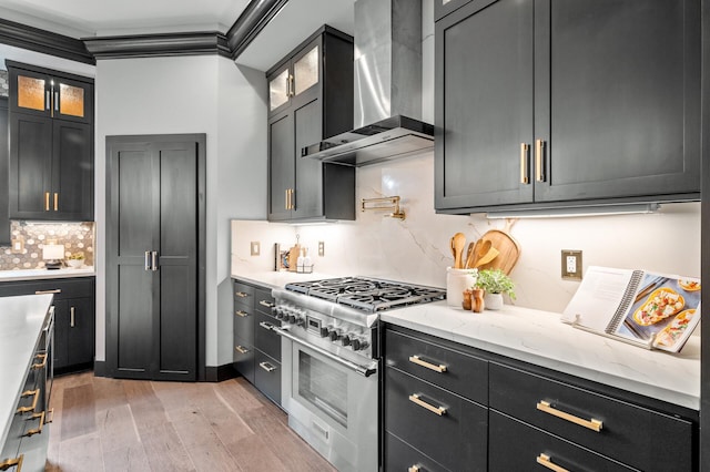 5191 159th Ave NW, Andover, MN 55304 - kitchen featuring wall chimney exhaust hood, stainless steel range, light wood finished floors, tasteful backsplash, and glass insert cabinets
