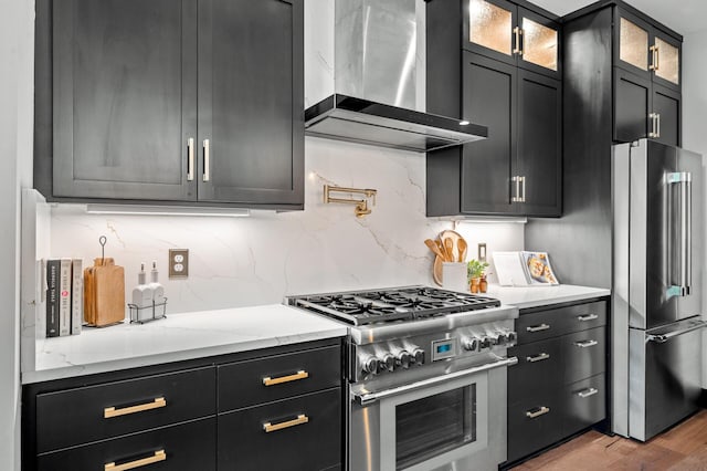 5191 159th Ave NW, Andover, MN 55304 - kitchen featuring appliances with stainless steel finishes, wall chimney exhaust hood, tasteful backsplash, and dark cabinets