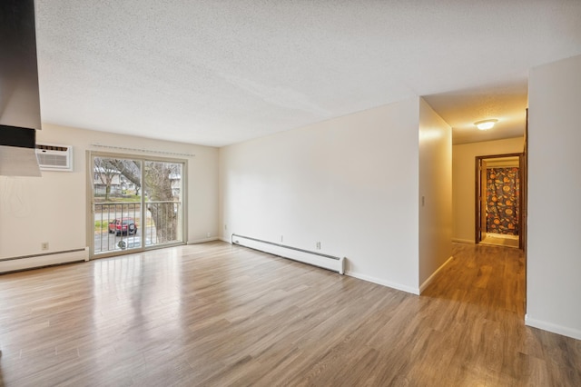 923 11th Ave S Unit 8, Hopkins, MN 55343 - unfurnished living room with wood finished floors, a textured ceiling, an AC wall unit, baseboard heating, and baseboards