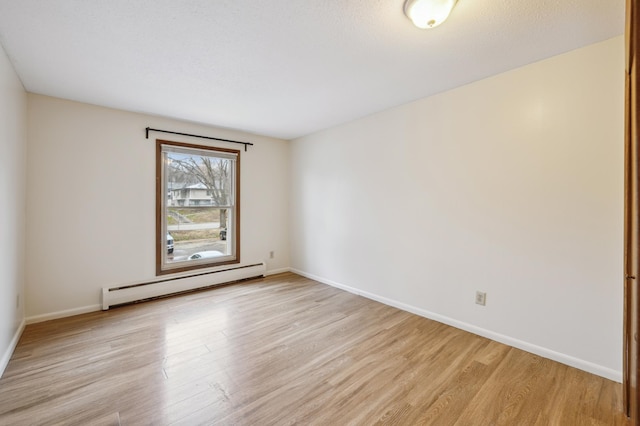 923 11th Ave S Unit 8, Hopkins, MN 55343 - spare room with light wood finished floors, baseboards, and a baseboard radiator