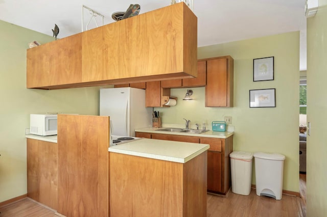 1494 21st Ave NW Unit 4, New Brighton, MN 55112 - kitchen featuring white appliances, light countertops, a sink, light wood finished floors, and a peninsula