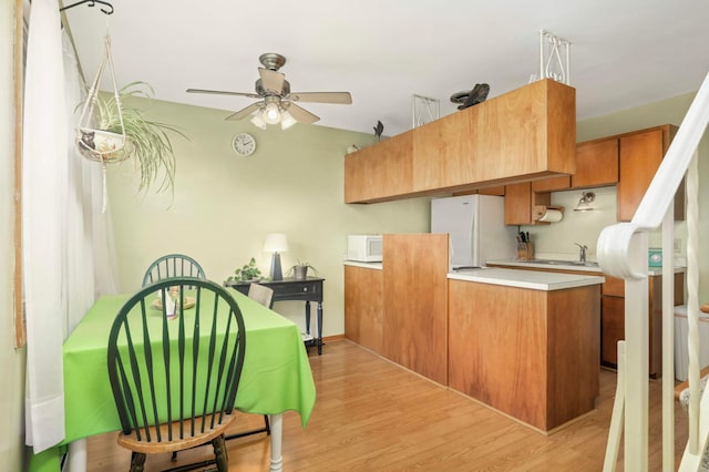 1494 21st Ave NW Unit 4, New Brighton, MN 55112 - kitchen with white appliances, a ceiling fan, a peninsula, light wood-style floors, and light countertops