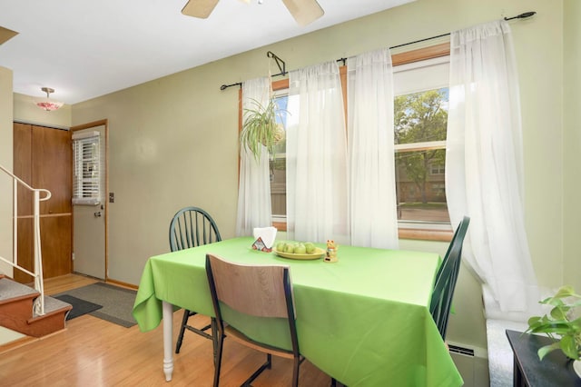 1494 21st Ave NW Unit 4, New Brighton, MN 55112 - dining space with stairs, a baseboard heating unit, wood finished floors, and ceiling fan