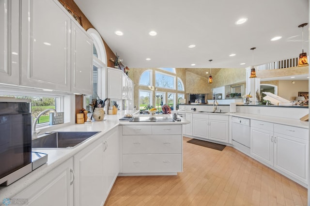 4126 Timberline Dr S, Fargo, ND 58104 - kitchen featuring dishwasher, a sink, white cabinetry, black electric stovetop, and light countertops