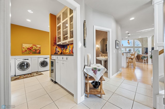 4126 Timberline Dr S, Fargo, ND 58104 - laundry area with washing machine and clothes dryer, light tile patterned floors, beverage cooler, a bar, and decorative columns