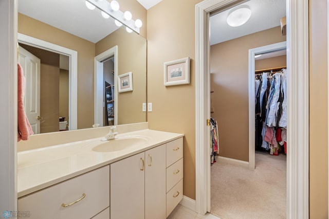 4126 Timberline Dr S, Fargo, ND 58104 - bathroom featuring vanity, a walk in closet, and baseboards