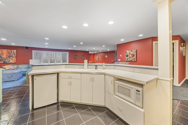 4126 Timberline Dr S, Fargo, ND 58104 - kitchen featuring light countertops, cream cabinets, white microwave, open floor plan, and recessed lighting