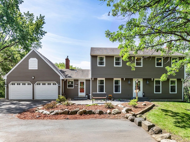 12576 Ridgewood Dr NW, Elk River, MN 55330 - colonial-style house with asphalt driveway, a garage, a front yard, and a chimney