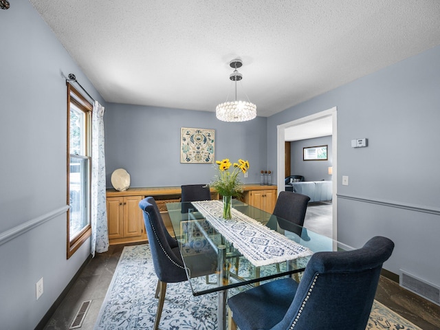 12576 Ridgewood Dr NW, Elk River, MN 55330 - dining area with a textured ceiling, healthy amount of natural light, a chandelier, dark wood-style floors, and baseboards