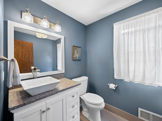12576 Ridgewood Dr NW, Elk River, MN 55330 - bathroom with vanity, toilet, and baseboards