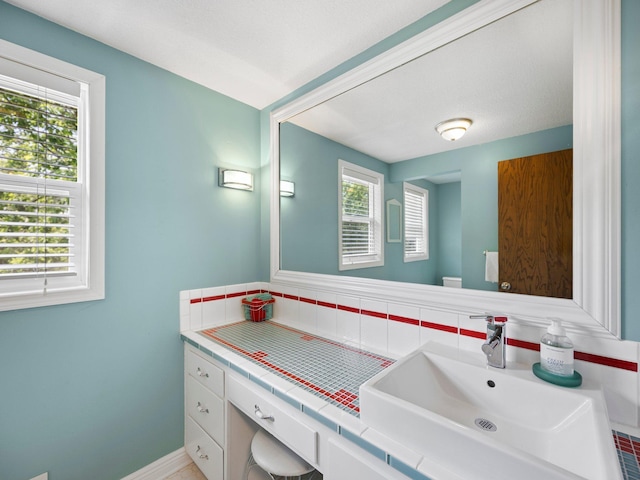 12576 Ridgewood Dr NW, Elk River, MN 55330 - bathroom featuring vanity, tasteful backsplash, and baseboards