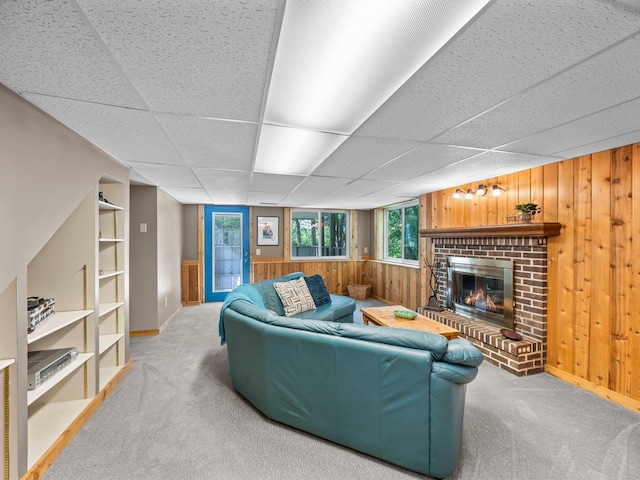 12576 Ridgewood Dr NW, Elk River, MN 55330 - carpeted living room with wood walls, baseboards, a fireplace, and a drop ceiling
