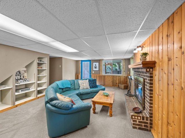 12576 Ridgewood Dr NW, Elk River, MN 55330 - carpeted living room featuring wood walls, a fireplace, and a drop ceiling
