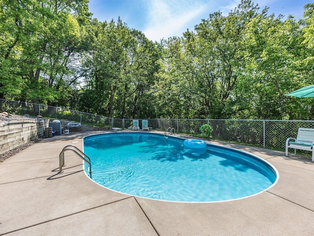 12576 Ridgewood Dr NW, Elk River, MN 55330 - view of swimming pool featuring a patio and view of wooded area