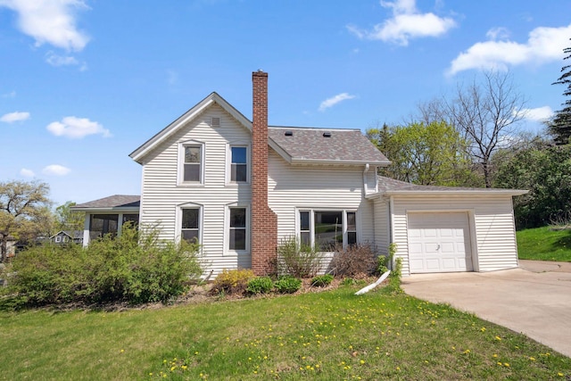 traditional-style home featuring a chimney, a garage, concrete driveway, and a front lawn