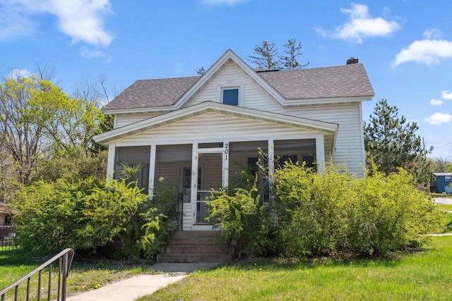 bungalow featuring a shingled roof and a chimney