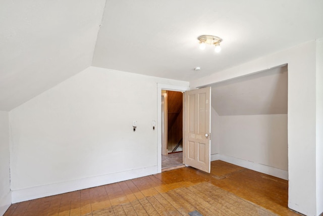 bonus room with lofted ceiling, hardwood / wood-style floors, and baseboards