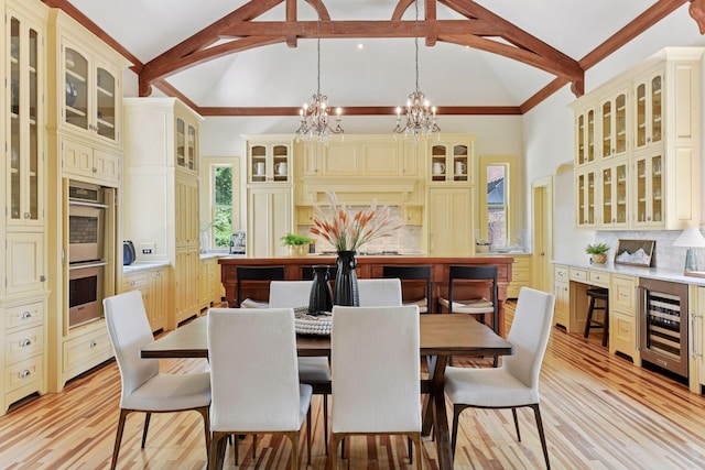 1721 Mount Curve Ave, Minneapolis, MN 55403 - dining room with beverage cooler, a chandelier, beam ceiling, light wood-type flooring, and high vaulted ceiling