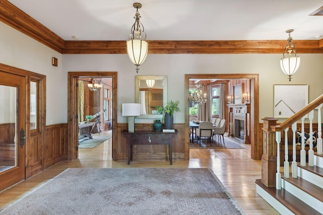 1721 Mount Curve Ave, Minneapolis, MN 55403 - foyer entrance with wood finished floors, wainscoting, stairs, a fireplace, and a chandelier