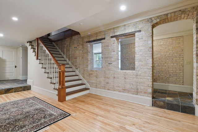 1721 Mount Curve Ave, Minneapolis, MN 55403 - below grade area featuring baseboards, stairway, brick wall, wood finished floors, and recessed lighting