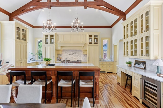 1721 Mount Curve Ave, Minneapolis, MN 55403 - kitchen featuring cream cabinets, wine cooler, beam ceiling, tasteful backsplash, and light wood-style flooring