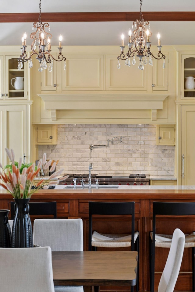 1721 Mount Curve Ave, Minneapolis, MN 55403 - kitchen with cream cabinets, a chandelier, and tasteful backsplash