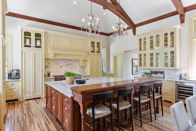1721 Mount Curve Ave, Minneapolis, MN 55403 - kitchen featuring cream cabinetry, beverage cooler, decorative backsplash, beamed ceiling, and high vaulted ceiling