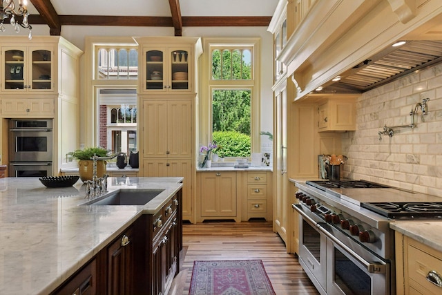 1721 Mount Curve Ave, Minneapolis, MN 55403 - kitchen featuring appliances with stainless steel finishes, custom exhaust hood, a sink, decorative backsplash, and beamed ceiling
