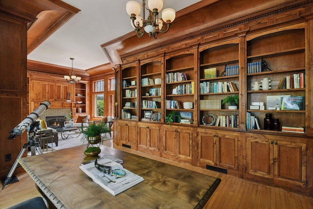 1721 Mount Curve Ave, Minneapolis, MN 55403 - living area featuring a chandelier, wood-type flooring, crown molding, a fireplace, and built in shelves