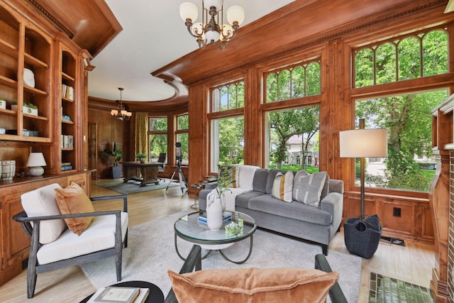 1721 Mount Curve Ave, Minneapolis, MN 55403 - living room with a chandelier, wood walls, wood finished floors, and ornamental molding