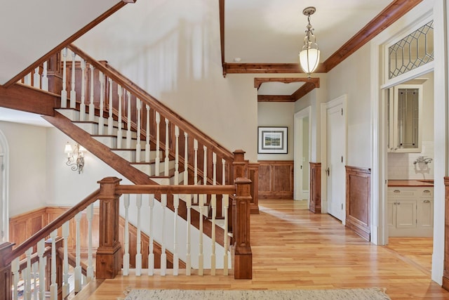 1721 Mount Curve Ave, Minneapolis, MN 55403 - stairway featuring wood finished floors, wainscoting, ornamental molding, and a decorative wall