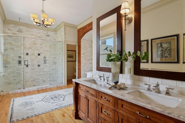 1721 Mount Curve Ave, Minneapolis, MN 55403 - bathroom with double vanity, a stall shower, wood finished floors, a chandelier, and toilet
