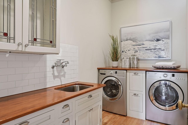 1721 Mount Curve Ave, Minneapolis, MN 55403 - washroom with washing machine and dryer, light wood-type flooring, and cabinet space