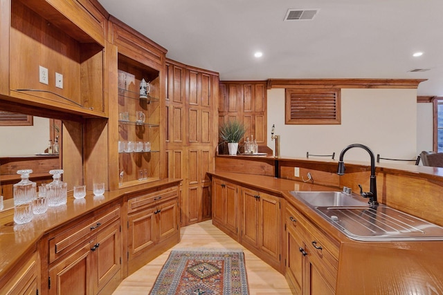 1721 Mount Curve Ave, Minneapolis, MN 55403 - kitchen with a sink, recessed lighting, brown cabinetry, light wood finished floors, and a peninsula