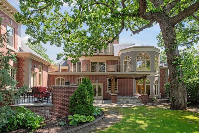 1721 Mount Curve Ave, Minneapolis, MN 55403 - view of front of house with a balcony, french doors, a patio, brick siding, and a front yard