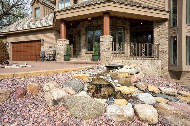 doorway to property featuring brick siding and an attached garage