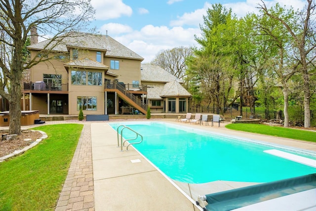 view of pool with a hot tub, a patio area, a wooden deck, stairs, and a diving board