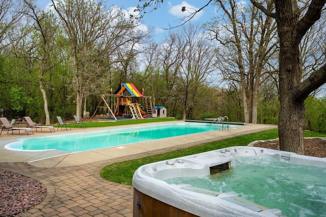 swimming pool with a hot tub, a playground, and a patio area