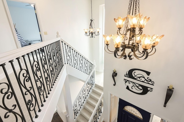 staircase with a chandelier and a towering ceiling