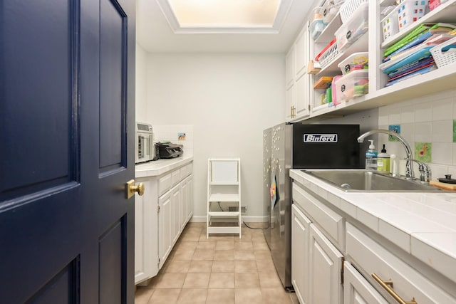 laundry room featuring light tile patterned floors, separate washer and dryer, and cabinet space