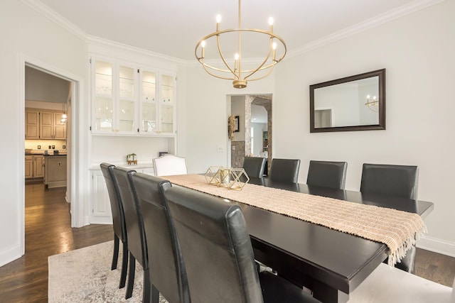 dining space with a chandelier, ornamental molding, dark wood finished floors, and baseboards