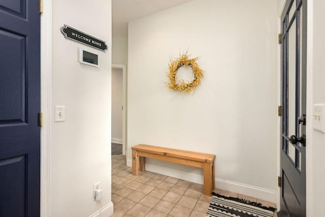 foyer entrance with light tile patterned flooring and baseboards