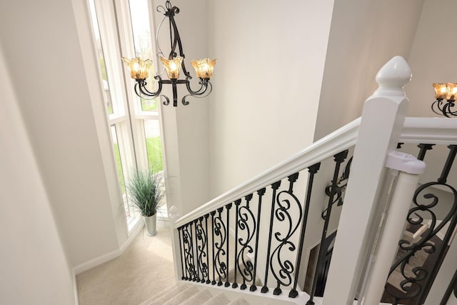 staircase featuring a chandelier and carpet flooring