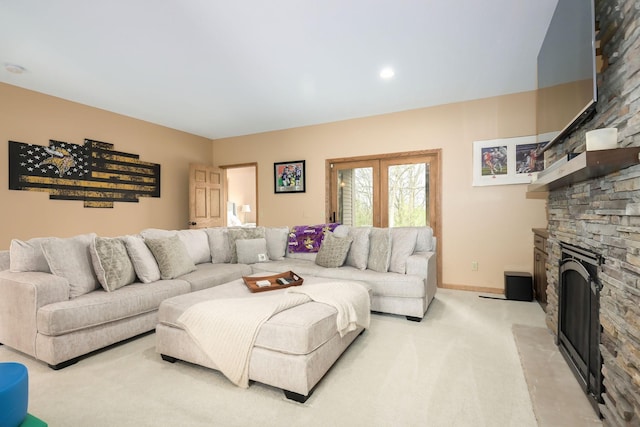 living area with light colored carpet, a fireplace, and baseboards