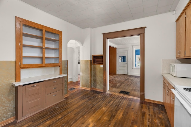 305 Pierson Ave, New Richmond, WI 54017 - kitchen with white appliances, arched walkways, dark wood-style floors, and light countertops
